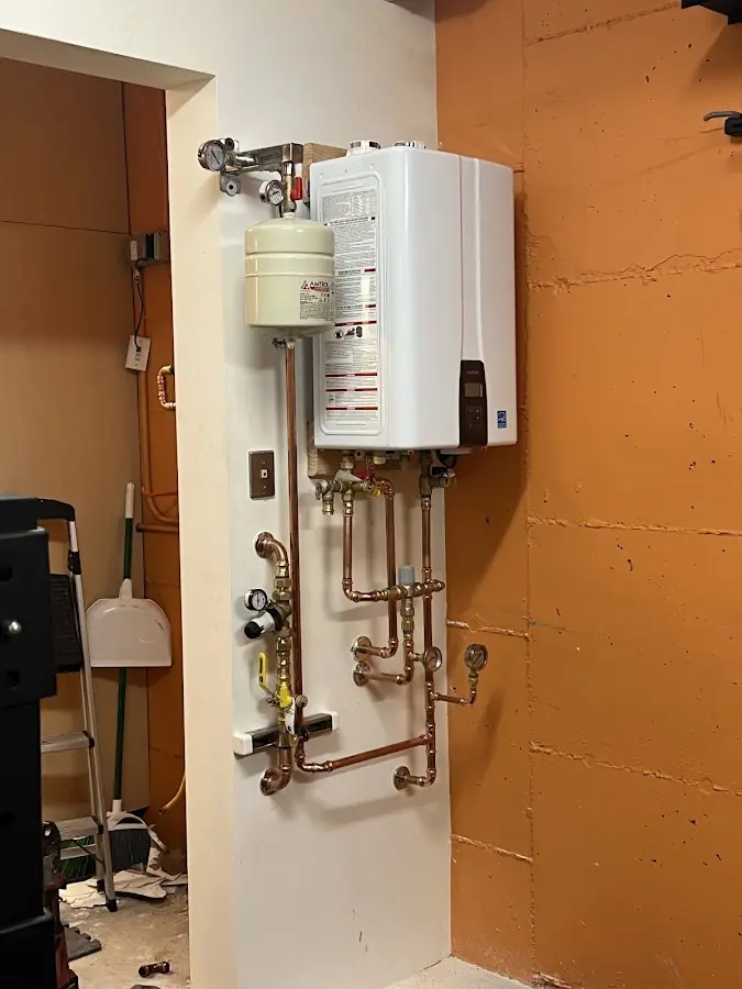 Plumbing technician inspecting water heater connections in Chester